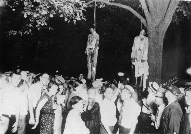 Lin%C4%8Danje+dveh+temnopoltih+mo%C5%A1kih+pred+5000-glavo+mno%C5%BEico+belcev+leta+1935.%0AFoto%3A+Proifimedia